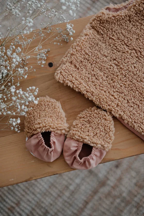 Driedelige teddyset voor baby's in taupe, inclusief vest, muts en anit-slip slofjes, beschikbaar in maten 0-12 maanden en 12-24 maanden.