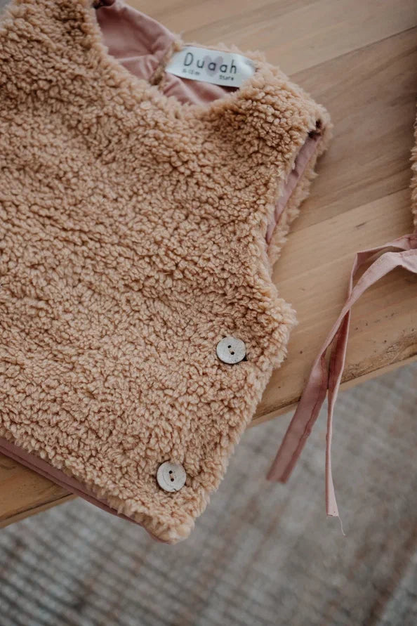 Driedelige teddyset voor baby's in taupe, inclusief vest, muts en anit-slip slofjes, beschikbaar in maten 0-12 maanden en 12-24 maanden.