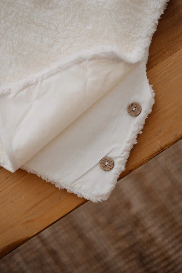 Driedelige teddyset voor baby's in ecru, inclusief vest, muts en anit-slip slofjes, beschikbaar in maten 0-12 maanden en 12-24 maanden.