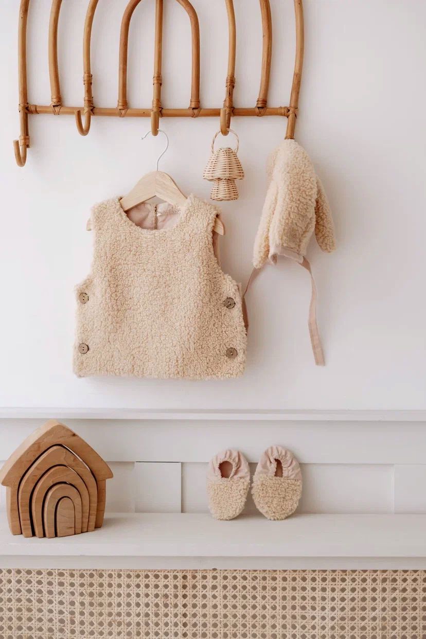 Driedelige teddyset voor baby's in beige, inclusief vest, muts en anit-slip slofjes, beschikbaar in maten 0-12 maanden en 12-24 maanden.