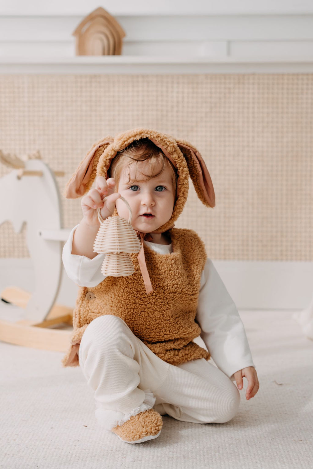 Driedelige teddyset voor baby's in taupe, inclusief vest, muts en anit-slip slofjes, beschikbaar in maten 0-12 maanden en 12-24 maanden.